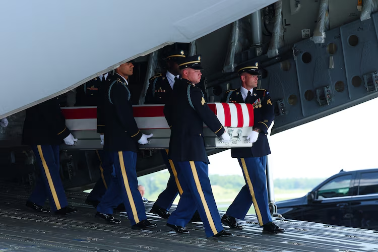 U.S. Army carry team moves a flag-draped transfer case at Dover Air Force Base