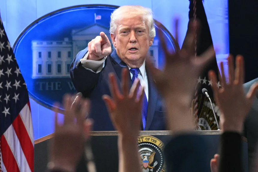President Donald Trump speaks at a White House briefing as reporters raise their hands